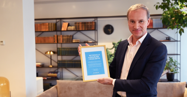 Henrik Kjellander från Setterwalls håller upp ett diplom av Läxhjälpen